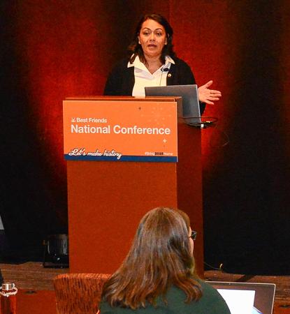 Person presenting at a podium at a Best Friends National Conference with attendees in the foreground