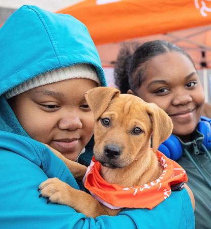 Family holding two puppies at a Best Friends adoption event at Walmart
