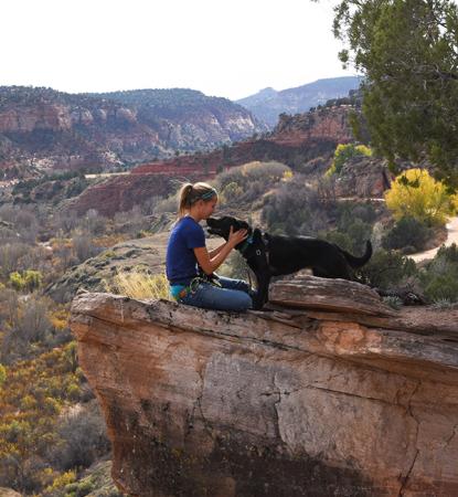 Person and dog on a cliff in Angel Canyon