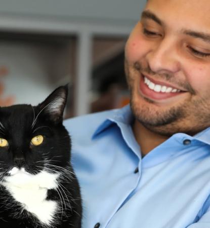Smiling person holding a cat