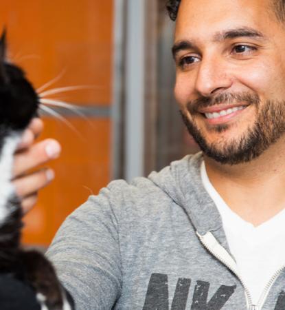 Smiling person talking to a person holding a cat