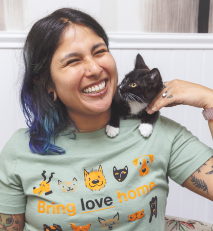 Hispanic woman with tuxedo cat on her shoulders