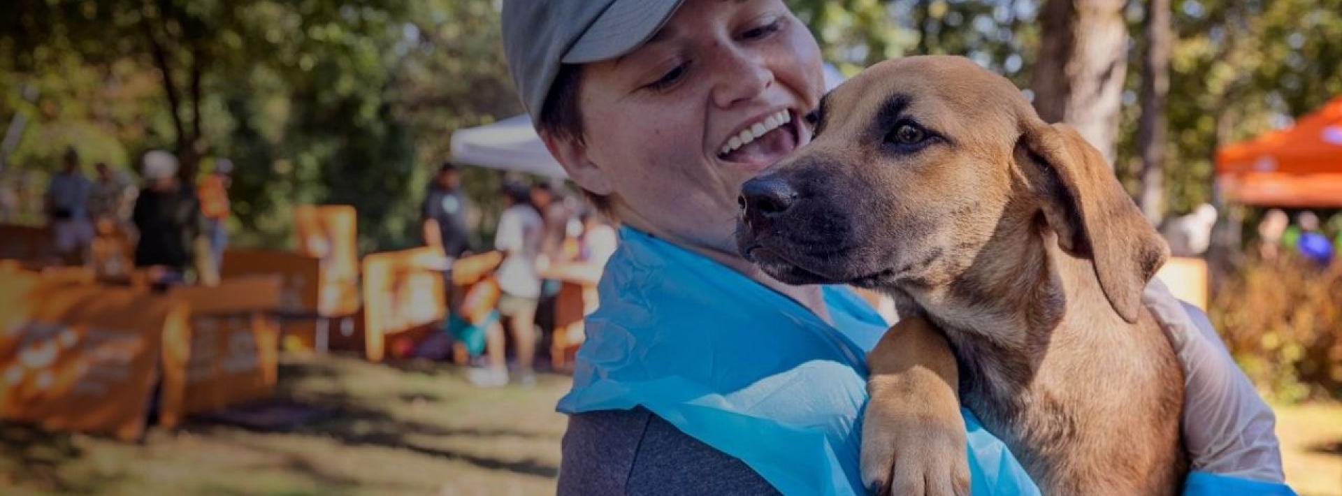 Happy adopter holding up their new puppy.
