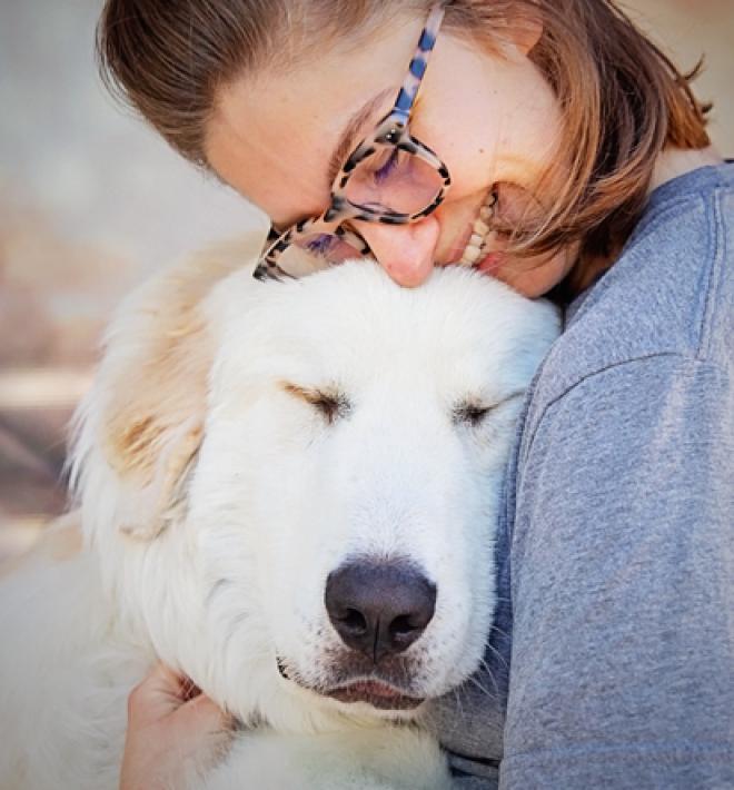 Person hugging a large white dog