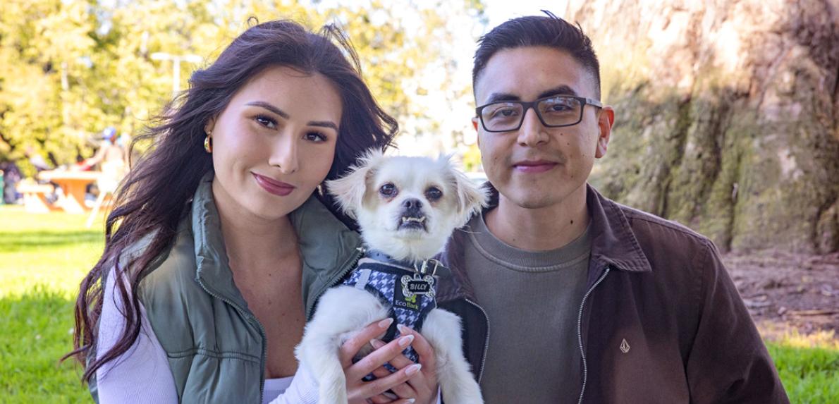 Couple holding a small white dog
