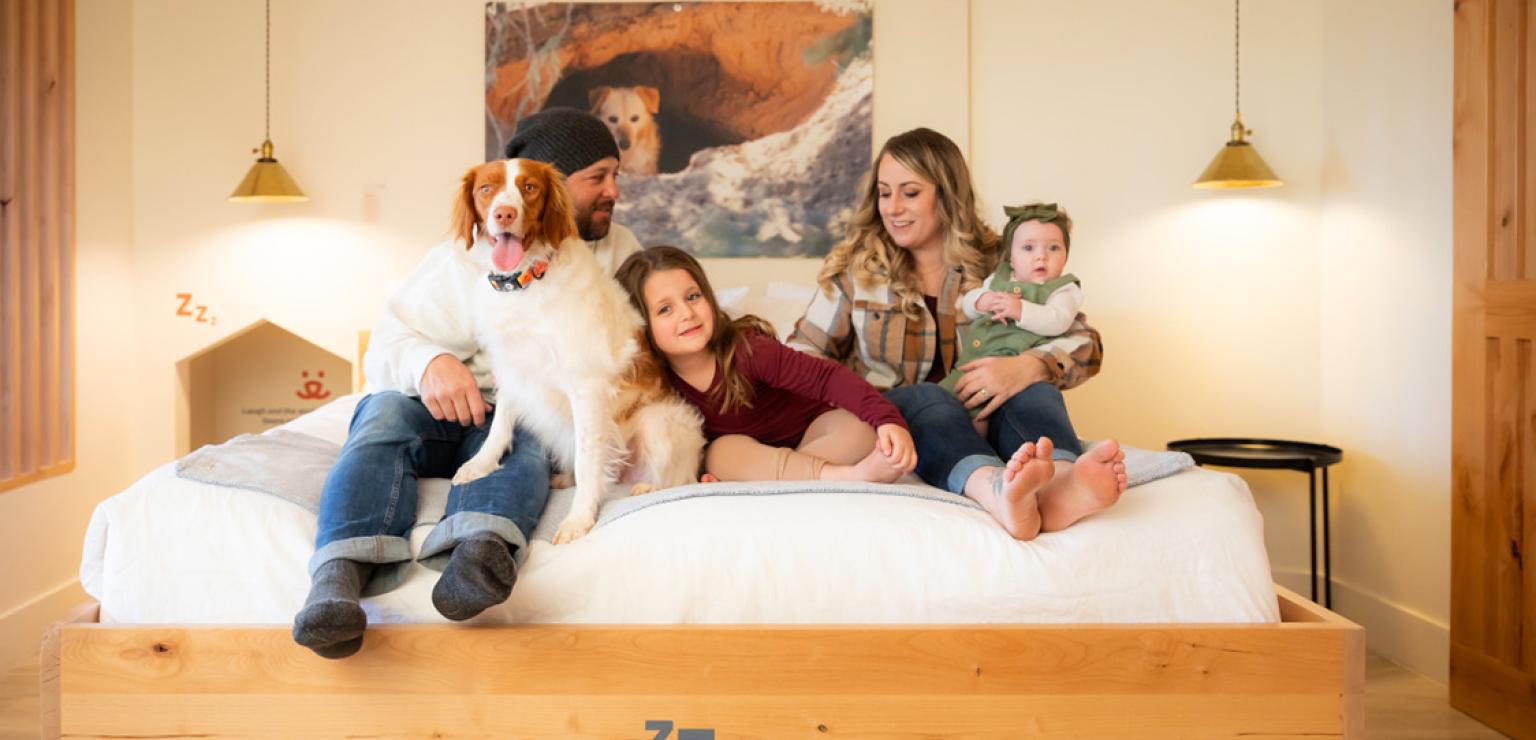 Family with a dog on a bed