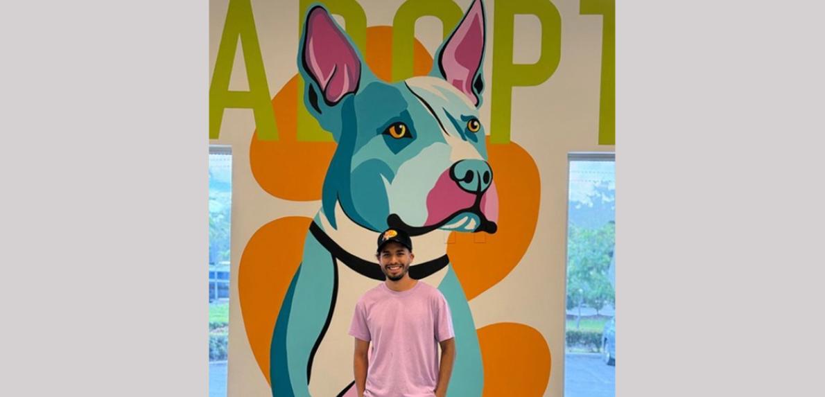 Jonathan Ramírez in front of his mural