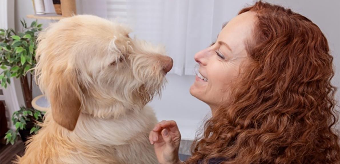 Woman and scruffy dog looking at each other