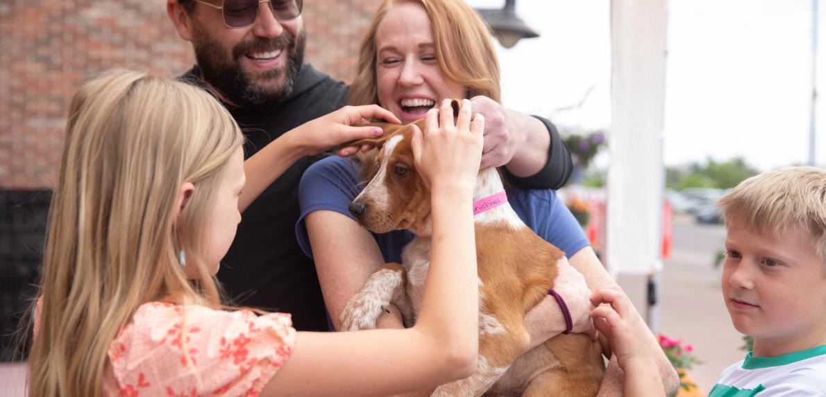 Family adopts a dog at a Best Friends and Walmart event during National Pet Month.
