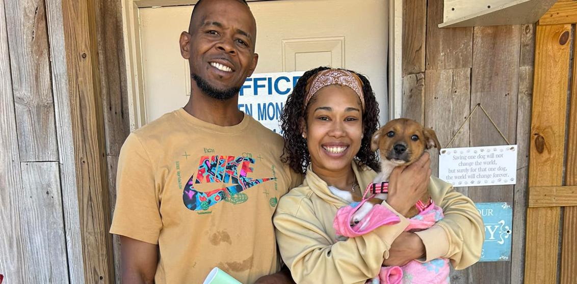 Couple holding their newly adopted puppy