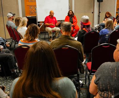 Two people presenting at the Best Friends National Conference in a smaller room with people seated closely
