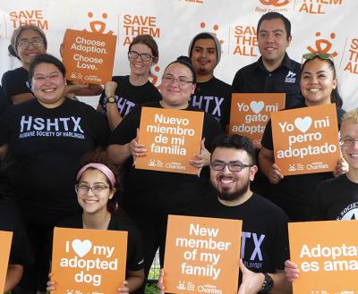 Group of people from the Humane Society of Harlingen holding orange signs 