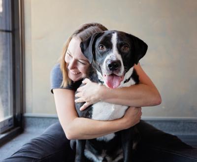 Woman hugging brown and white dog