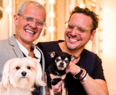 Two smiling people sitting with two small dogs in New York City