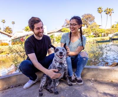 Smiling people sitting outside with a dog in Los Angeles