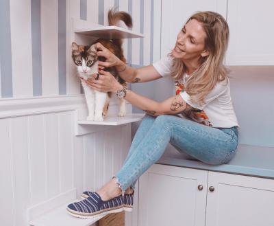 Person wearing BOBS® from Skechers® petting a calico cat
