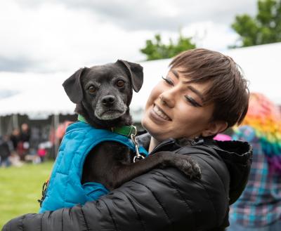 Smiling person holding a dog at a pet adoption event