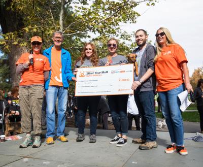 People holding a large check at a Salt Lake City Strut Your Mutt event