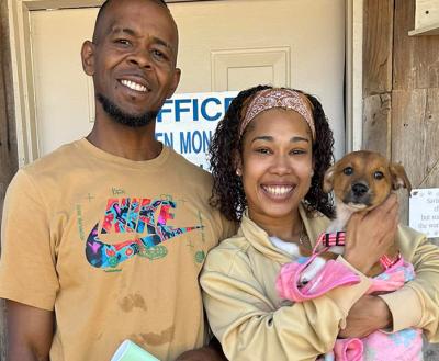 Couple holding their newly adopted puppy