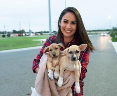 Woman holding two dogs for transport
