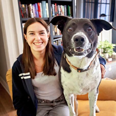 Woman and medium brown and white dog sitting on chair in living room