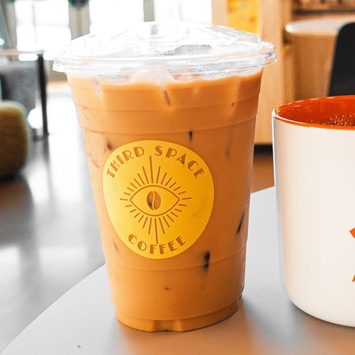 Best Friends coffee mug next to a Third Space Coffee cup filled with iced coffee