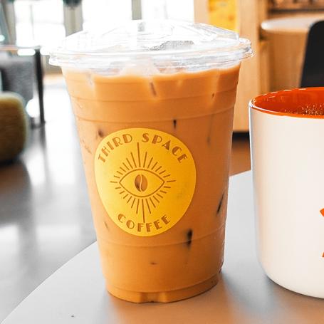 Best Friends coffee mug next to a Third Space Coffee cup filled with iced coffee