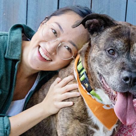 Woman hugging dog outside on patio