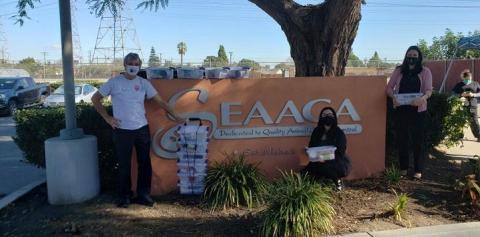 People with kitten kits standing in front of shelter sign