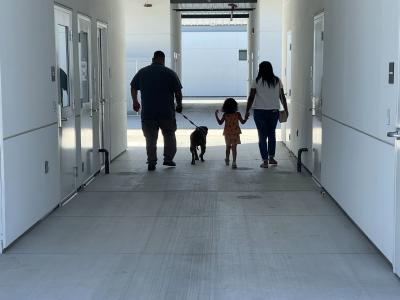 The backs of Mac the dog and his family as they're leaving the shelter together