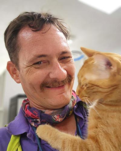 Gregory Brandt holding an orange tabby cat