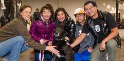 A family very happy with a black senior dog