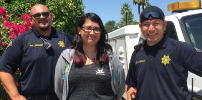 Two animal control officers stand beside a Best Friends employee