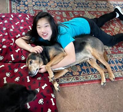 Person lying on a carpet with Arlo the dog