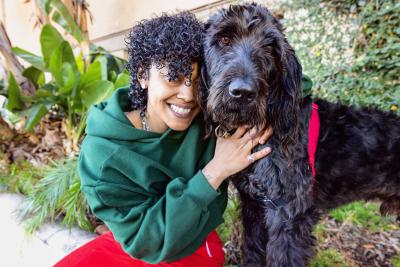 Gillian smiling and hugging Hagrid the dog