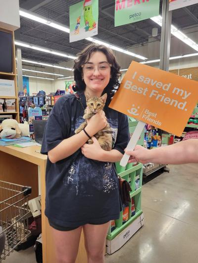 Genevieve holding Buttons the kitten and a sign that says, 'I saved my Best Friend'