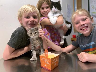 Three children with two cats and the Best Friends adoption cake