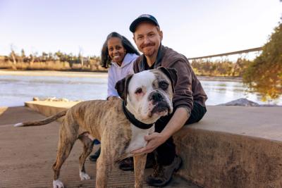 Couple with Otis the dog next to some water