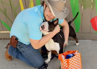 Steven Szydio hugging Chico the dog during Adventure Buddy Day