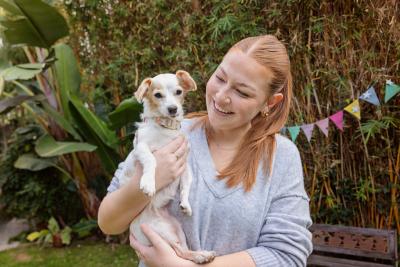 Smiling person holding a small dog