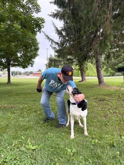 Anastasia the dog with her adopter looking affectionately at each other outside 