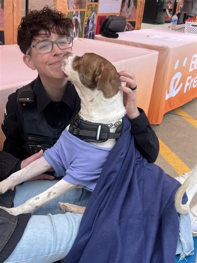 Cookie Dough the dog with his adopter beside a Best Friends booth