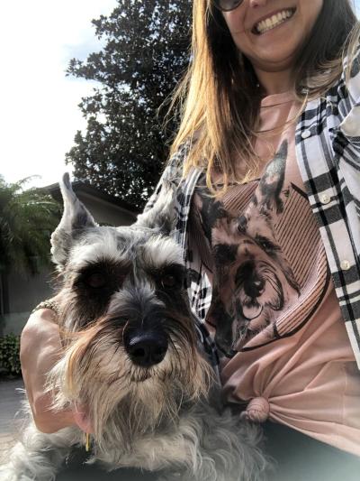 Chlie smiling with her hand affectionately holding Crusoe the dog