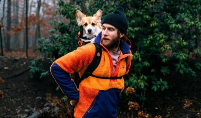 Bryan Reisberg outside with a dog in his Little Chonk backpack