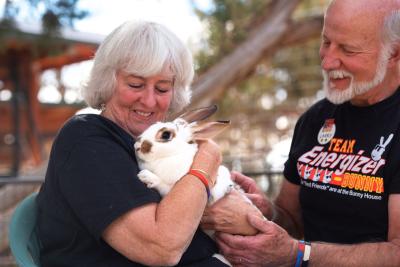 Two volunteers sitting with a bunny outside