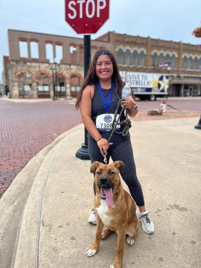 Elliott the race winning dog with a person at a stop sign