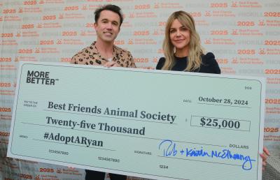 Rob McElhenney and Kaitlin Olson holding a large check for $25,000 for Best Friends Animal Society at the Los Angeles Super Adoption