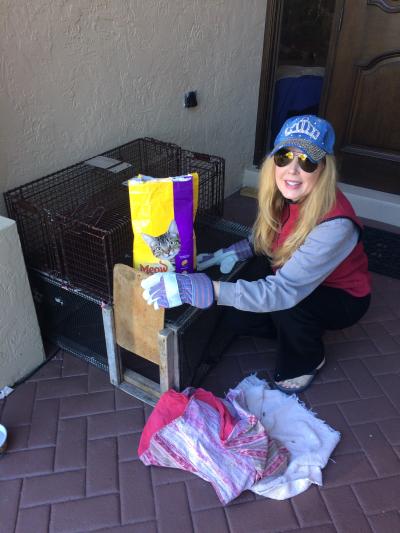 Beth Janser beside some live traps and a bag of cat food