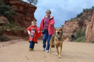 Volunteer Betty Grieb walking a dog in Angel Canyon along with a child