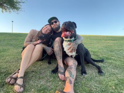 Big Hoss the dog and his new family sitting together outside on grass